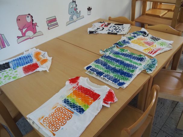 Kinder bemalen Holzlatten und stellen bunte Blumentröge her