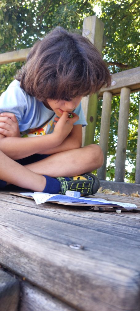 Kinder lesen und schreiben auf dem Spielplatz und im Treppenhaus