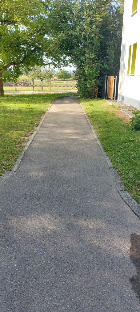 Kinder bemalen den Schulhof mit bunten Farben